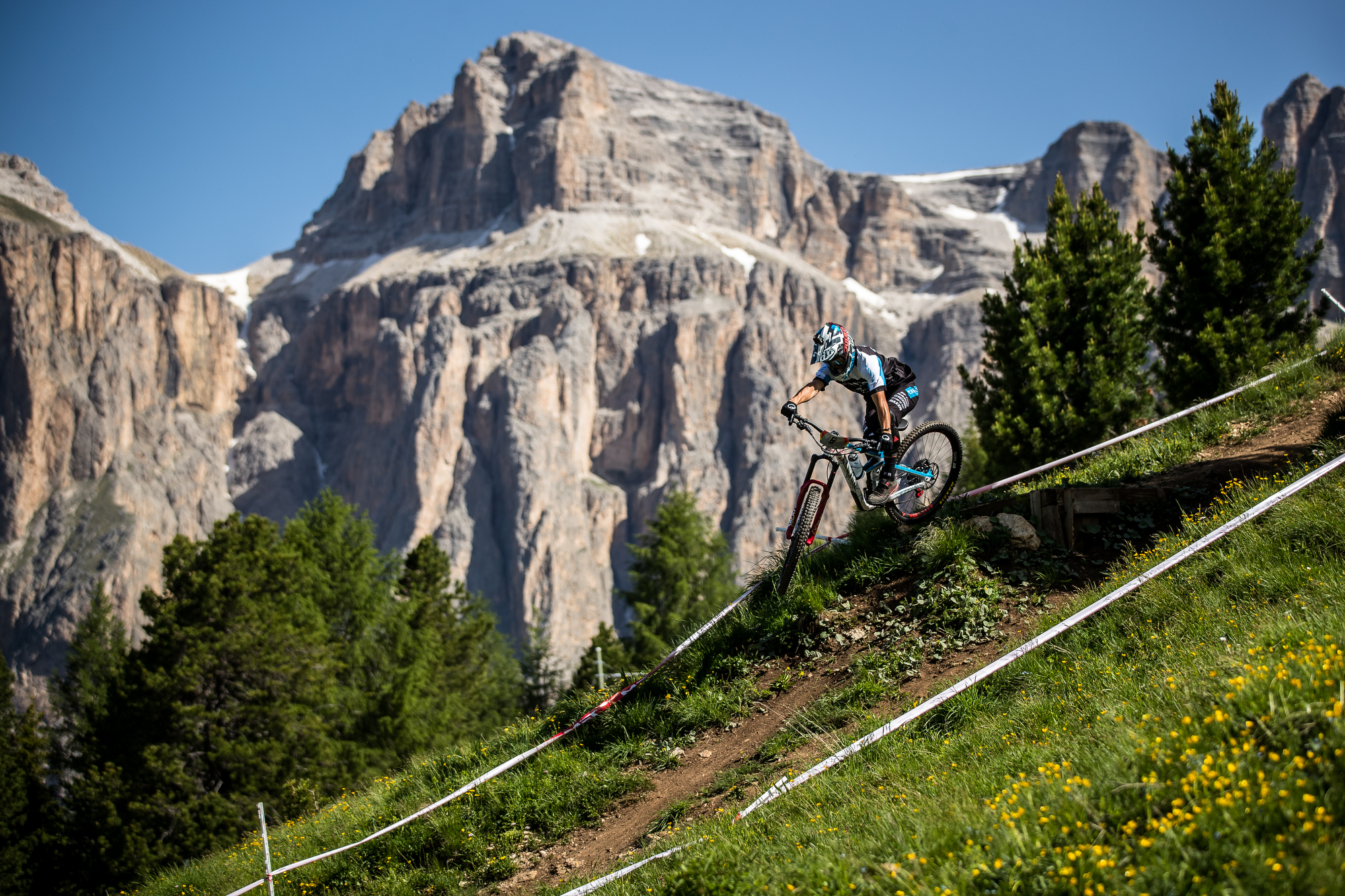 Dimitri Tordo sails off of a drop in front of a beautiful mountain setting.